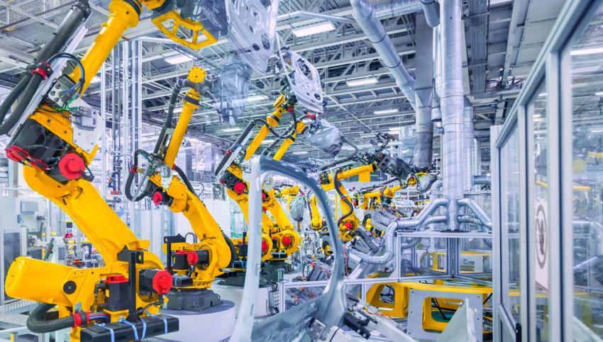 Yellow robot arms at an automotive assembly factory